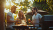 © Elena - Three friends are enjoying a summer barbecue outdoors while holding drinks beer and chatting happily.