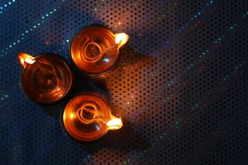 Wall Mural - Diwali celebration. Diya lamps on color background, flat lay. Space for text