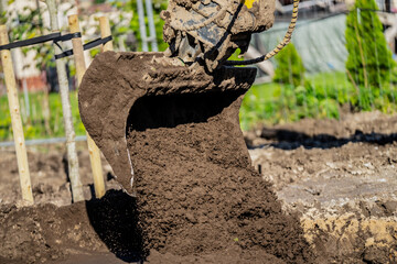 Muddy and dirty excavator digging ground and soil for coming construction project of building new houses