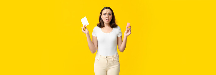 Wall Mural - Beautiful shocked woman with menstrual pad and cup on yellow background