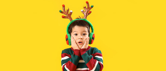 Sticker - Surprised little boy in reindeer horns on yellow background