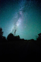Wall Mural - Space with galaxy . Milky way on the blue sky .Dark and cold night at summer . Trees on the backgound with stars . Power lines in the night , powerstation and galaxy
