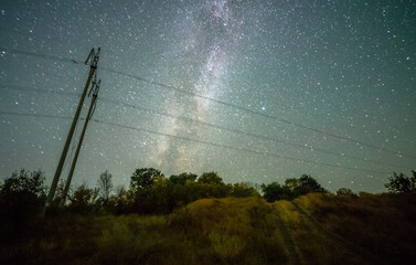 Wall Mural - Space with galaxy . Milky way on the blue sky .Dark and cold night at summer . Trees on the backgound with stars . Power lines in the night , powerstation and galaxy