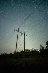 Wall Mural - Space with galaxy . Milky way on the blue sky .Dark and cold night at summer . Trees on the backgound with stars . Power lines in the night , powerstation and galaxy
