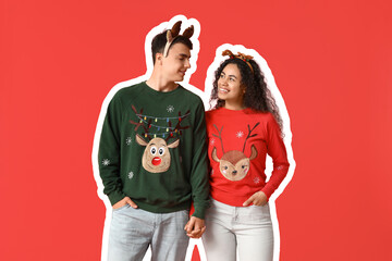 Wall Mural - Happy young couple in Christmas sweaters on red background