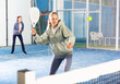 © JackF - Sportive young girl with racquet playing padel in court.