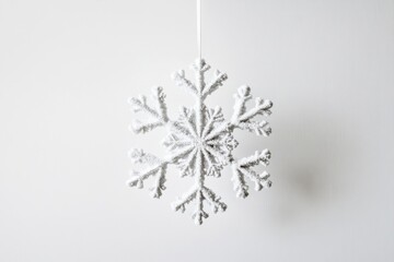 Sticker - A Glittery White Snowflake Ornament Hanging Against a White Background