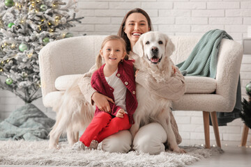 Poster - Happy young mother and her little daughter with cute Labrador dog at home on Christmas eve