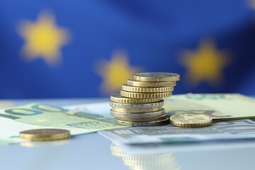 Coins and euro banknotes on table, closeup