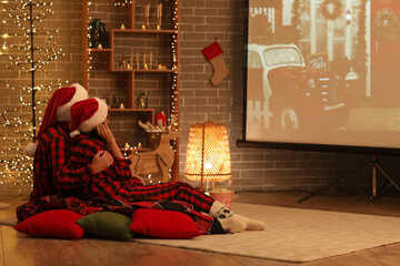 Poster - Young couple watching Christmas movie on projector screen at home