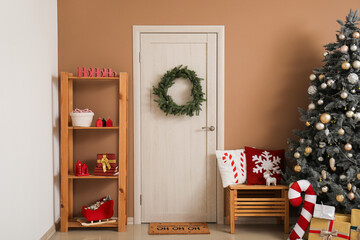 Sticker - Interior of festive room with Christmas tree, gift boxes, glowing lights and wreath on door