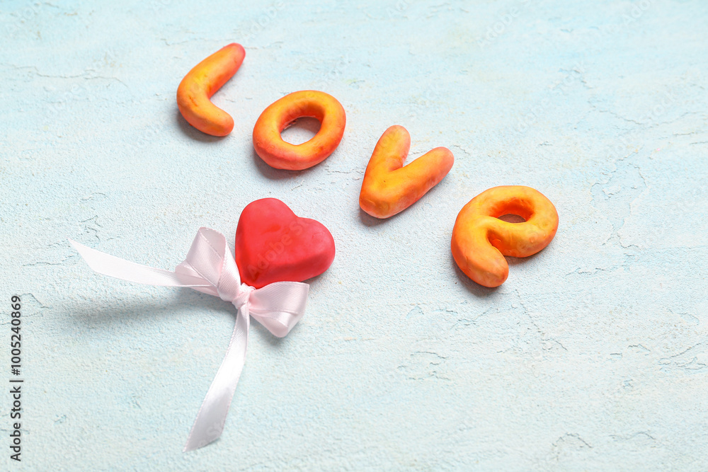 Composition with word LOVE and heart for Valentine's Day on light background