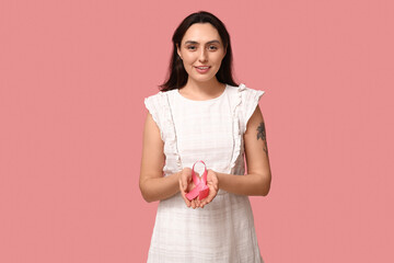 Poster - Pretty young woman with pink ribbon on color background. Breast cancer awareness concept