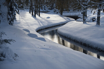 Winter scene with calm creek and frost-laden banks