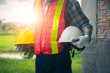 Businessman and engineer oversee construction in safety gear.