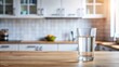 © Chanchai - Panoramic glass of water on kitchen table with kitchen background