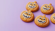 © Faisal - Halloweenthemed pumpkin gingerbread cookies with adorable kawaii faces arranged on a soft pastel purple background
