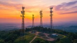 Telecommunication towers against a vibrant sunset sky, scenic landscape.