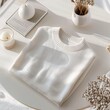 © DigitalArt - Cream sweater on minimalist white table soft shadows natural light top-down angle modern aesthetic mock up
