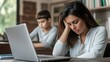 © Li - A busy mom sitting in front of her laptop, displaying a sad expression as she juggles her responsibilities. The scene captures the essence of motherhood in a modern world,