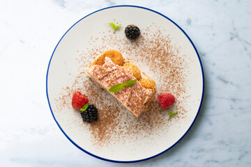 Wall Mural - Italian tiramisu with red berry cream. Top view table with  decorations.