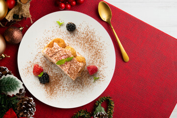 Wall Mural - Italian tiramisu with red berry cream. Top view table with Christmas decorations.