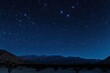 © Luxetify - A night sky filled with stars over a mountain range.