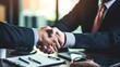 © Muhammad - Two businessmen shaking hands over a table, signifying agreement