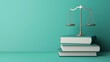 © Thi - A silver balance scale rests on three stacked books against a turquoise background, representing law, justice, and knowledge.