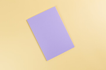 Wall Mural - Top view of purple notebook on yellow background. School, office wallpaper. Flat lay, copy space.