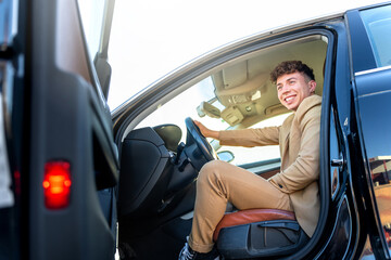 Portrait of a young businessman in a suit in his car