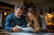 © mattegg - A man and a woman review a document together at a table