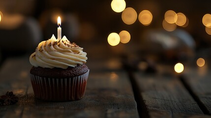 Poster - A chocolate cupcake with frosting and a candle, set against a blurred, warm-lit background.