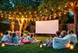 © abu - Kids watching a movie outdoors in a backyard cinema with lights and decorations.