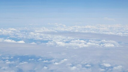 Wall Mural - view from plane over blue sky with white Fluffy clouds while flying through in sunny summer time.nature blue sky cloud and sun for Clean Environment, save energy or transportation holiday concept. 