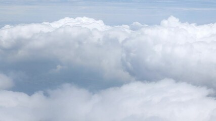 Wall Mural - view from plane over blue sky with white Fluffy clouds while flying through in sunny summer time.nature blue sky cloud and sun for Clean Environment, save energy or transportation holiday concept. 