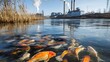 © Teeranan - A factory releases toxic waste into a river, with fish swimming near the surface in the foreground, highlighting the direct impact of industrial pollution on aquatic life