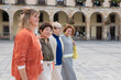 © ADDICTIVE STOCK - Diverse group of women smiling together in a city square