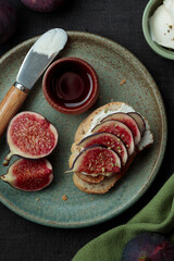 Close-up view of sandwich with fresh fig slices, cream cheese spread and honey on white bread. Healthy eating. Vegetarian breakfast, lunch or snack