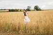 © svittlana - Young woman in white midi dress walking across the field with ripe golden ears of chickpeas. Beauty Romantic woman Outdoors