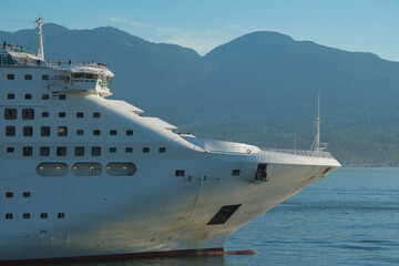 Cruiseship cruise ship liner P World arrival into Vancouver, BC port with scenic mountain glacier bay view, city skyline and marine traffic during sunrise morning	