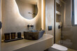© Maksym - Modern bathroom interior design with cave-like aesthetic, featuring soft beige tones creating warm and inviting atmosphere. Focal point includes unique stone-like sink with natural finish.