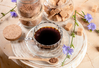 Wall Mural - Cup chicory tea, jars of granulated soluble chicory and cane sugar, spoon on wooden stump.