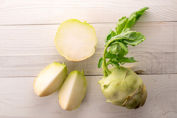 Wall Mural - One whole ripe kohlrabi and one cut lie on a wooden table, macro, top view.