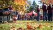 © Elmira - People engage in a lively tailgate gathering outdoors, grilling food and chatting cheerfully surrounded by autumn leaves and team flags fluttering