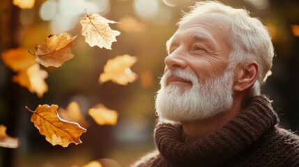 Canvas Print - Old man with trimmed white beard in autmn with falling foliage on a sunny day with sunlight, a bokeh effect, autumn time