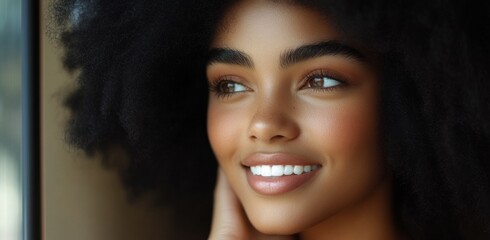 Sticker -  close-up of an African American woman with natural hair, smiling and looking off to the side as she touches her face gently in front of a window. 