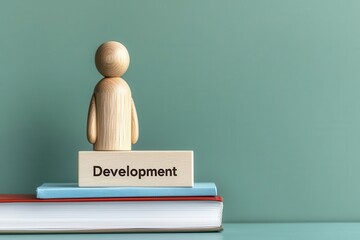 Wall Mural - wooden figure on books with sign labeled development, minimalist style design