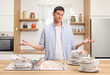 © Ljupco Smokovski - Angry man with a pile of dirty dishes in a kitchen sink