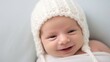 © MUMTAZ - Little baby boy with knitted hat, happily smiling